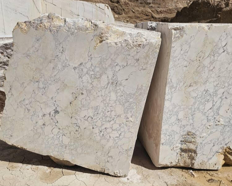 Bloques de mármol blanco con vetas grises en una cantera